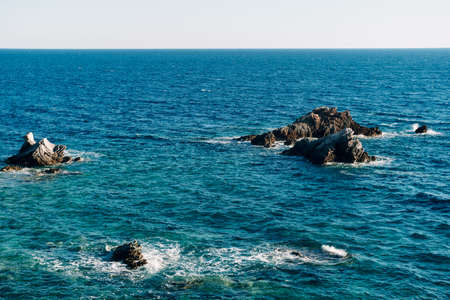 Rocks stick out from the sea.の写真素材
