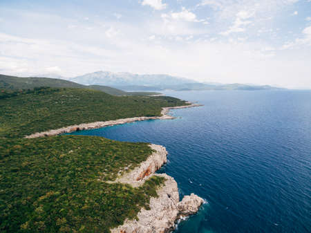 Rocky seaside near Veslo camping in Montenegro. Azure blue water, white waves hitting the rocks, sunny summer day, aerial drone view.の写真素材