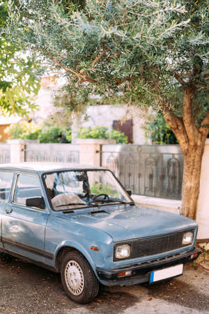 Zabljak, Montenegro - 23 july 2020: An old blue car parked under an olive tree in Montenegro, Perast.のeditorial素材