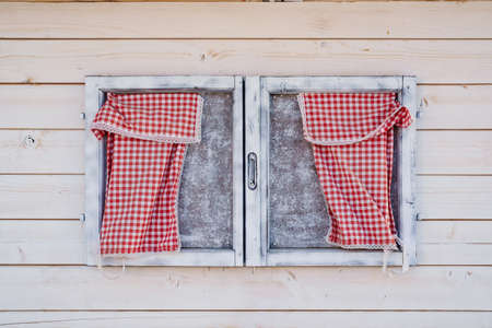 Wooden window on the wall of wooden boards with checkered napkins in red.の写真素材