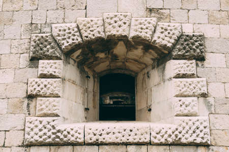 Window opening on a brick wall in the Mamula fortress in Montenegro.の写真素材