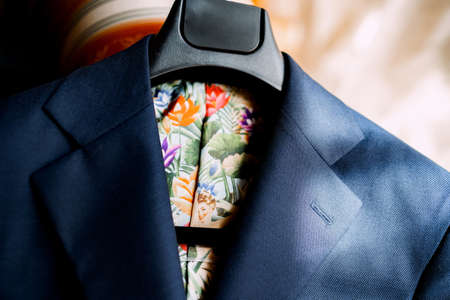 A bright blue jacket with a lining of colorful colors on a hanger.の写真素材