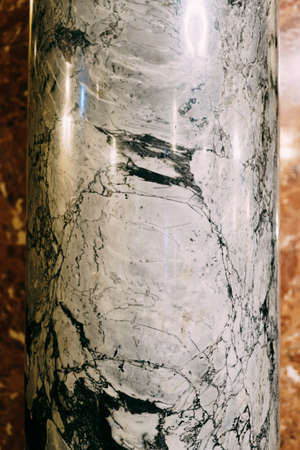 Close-up texture of glossy marble column with black pattern.
