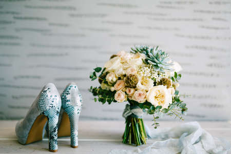 Gray suede shoes with snakeskin heels and bridal bouquet with silk ribbons, Austin roses, eucalyptus and succulents.の写真素材