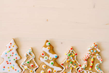 Gingerbread, handmade treats. Decorated Christmas trees with sprinkles and glaze on a white...