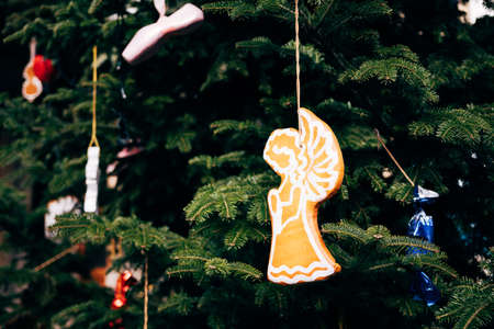 Wooden Christmas toy in the shape of an angel on the branches of a Christmas tree.の写真素材