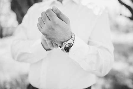 the groom fastens the watch on his wrist