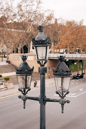 Metal pole with street lamps near the roadway.の写真素材