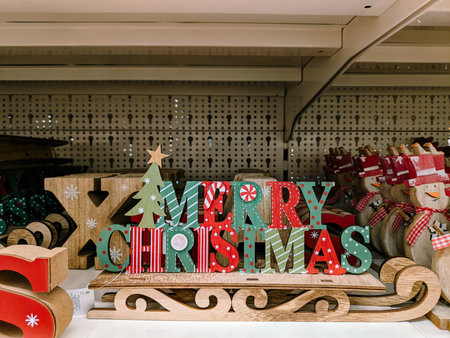 Budva, Montenegro - 15 December 2020: Wooden toy decoration in the shape of a sleigh with a multicolored inscription MERRY CHRISTMASのeditorial素材