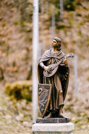 Bronze sculpture of a young guy with a musical instrument in his hands.の写真素材