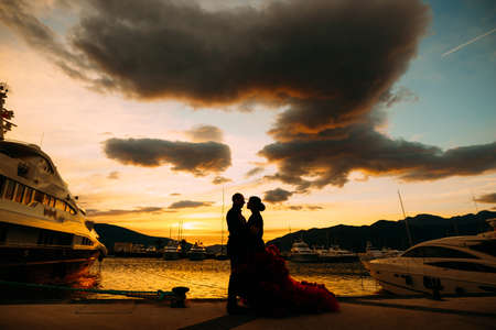 Couple hugging each other at sunset on a boat pierの写真素材