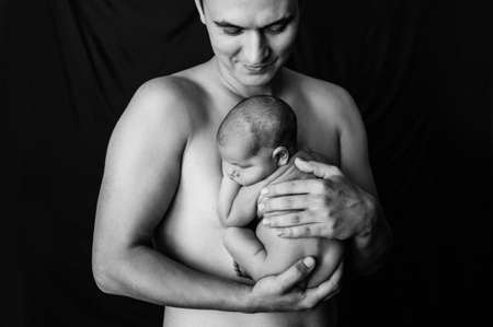 2. Father holding his newborn daughter at a newborn photoshoot