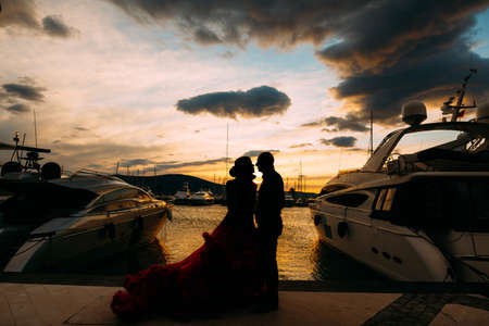 Couple embracing each other at sunset on a boat pierの写真素材
