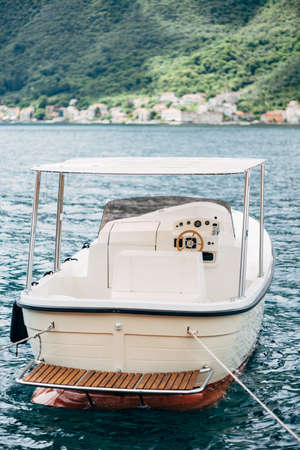 White pleasure boat with awning, rear view. Moored in the water.の写真素材