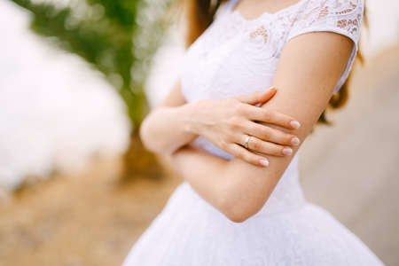 The bride in a delicate white dress folded her arms close upの写真素材