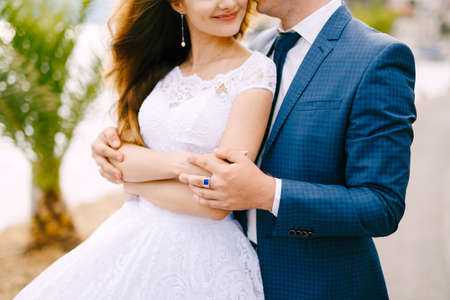 The bride and groom are embracing on the pier in Perast, close-upの写真素材