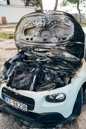 Budva, Montenegro - 17 march 2021: Citroen C3 2016 passenger car burnt out and extinguished by firefighters. Wiring under the hood caught fire.のeditorial素材