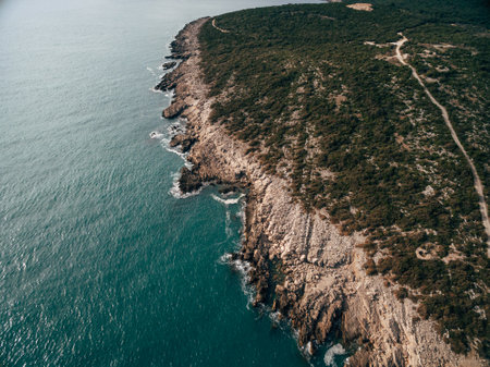 Rocky coast of the Lustica peninsula in Montenegro. Aerial drone view. Foamy waves hit the coast.の写真素材