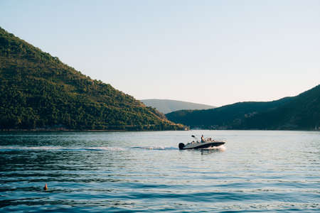 A motor boat with people on board is sailing along the Bay of Kotor.の写真素材