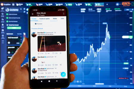 New York, USA - 16 April 2021: Holding a smartphone that has Elon Musks Twitter post on screen: Doge...