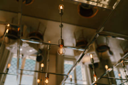 Mirrored ceiling with retro light bulbs in the interior of the restaurant.の写真素材