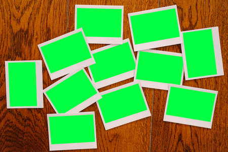 Many blank photographs lie on a wooden tableの写真素材