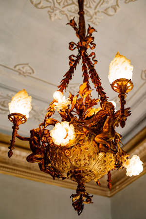 Massive metal chandelier with shades and floral patterns.の写真素材