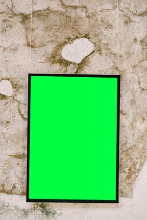 Empty vertical painting in black frame on stone wallの写真素材