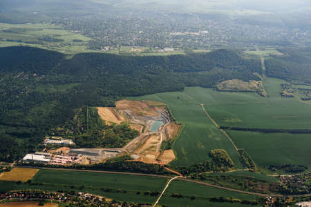 View from the plane window of the green plains and wooded hills of Budapest
