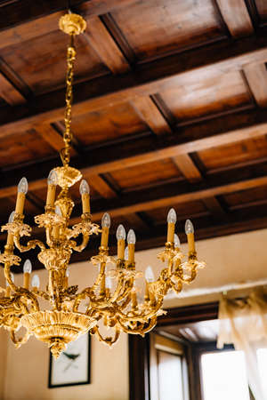 Close-up of an antique gold chandelier in the interior of an old villa.の写真素材