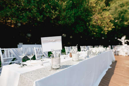 Empty sign stands on a beautifully served holiday table covered with a white tablecloth