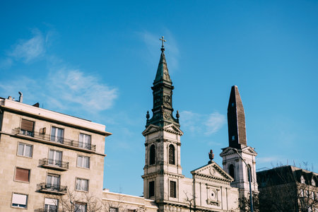 Spiers of a beautiful ancient basilica in Budapest against a blue sky with white cloudsの写真素材