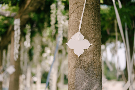 White paper decorative flower hanging on a ribbon on a pillar background. Wedding tentの写真素材