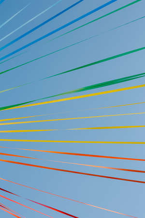 Colorful ribbons on the blue sky backdrop.の写真素材