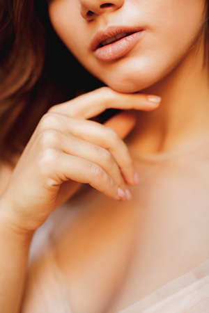 Half-portrait of a lovely girl in a pastel wedding dress and nude manicureの写真素材