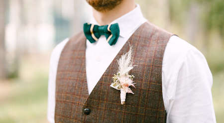 Half-length portrait of groom in white shirt green bow-tie and brown vestの写真素材