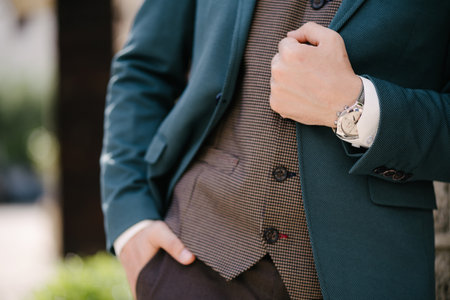 Groom holds his hand on the lapel of a blue jacket