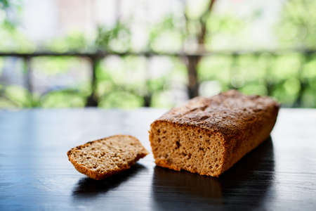 Fresh home-baked rye bread lie on a wooden table