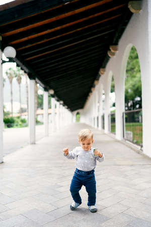 Kid walks on stone tiles in patioの写真素材