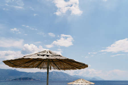 Top of a thatched beach umbrella against a blue skyの写真素材