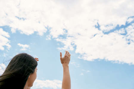 Girl raises her hands to the sky. Praying to God. Close-upの写真素材