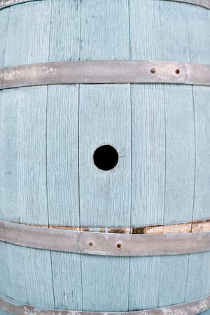 Side of a blue wooden barrel with a round holeの写真素材