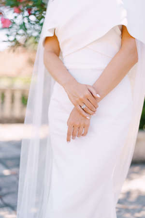 Hands of the bride with manicure in a white dress with a veil. Close-upの写真素材