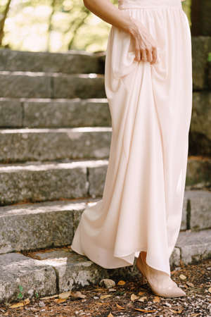 Bride in a wedding dress descends the stone steps. Close-upの写真素材