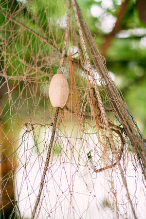 Float hangs on a rope on a fishing net. Close-up