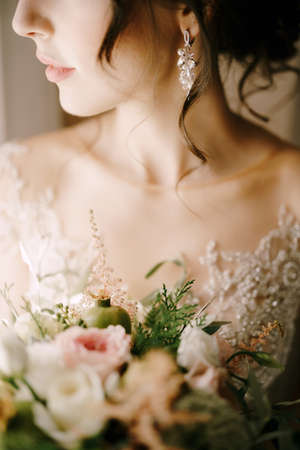 Bride in a dress with a bouquet of flowers. Close-upの写真素材