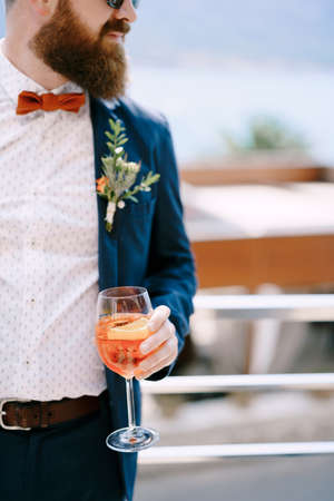 Bearded redhead groom with a glass in his handの写真素材