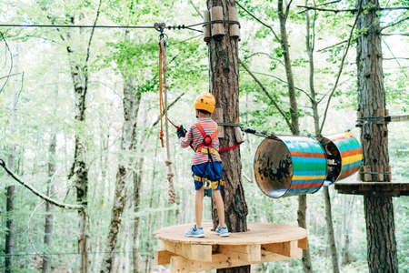 Boy stands on a wooden platform near the barrel sectionsの写真素材
