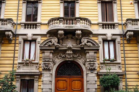 Central entrance to the old building with stucco and balconies. Milan, Italyの写真素材