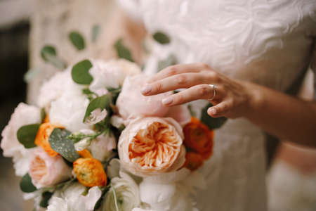 Bride holds a bouquet of multi-colored peonies in her hands. Close-upの写真素材